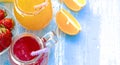 Orange and strawberry juice in glass on old wooden blue table Royalty Free Stock Photo