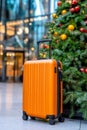 A suitcase sitting in front of a Christmas tree Royalty Free Stock Photo