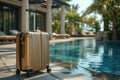 Orange suitcase by the pool in a tropical hotel atrium.