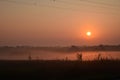 Foggy field with the sun rising over it