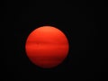 Forest fire smoke causes orange sun in black sky