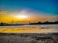 Orange Sundown over the sandy Beach of the river Rhein in Cologne with sky, Chappell and bridge landscape Royalty Free Stock Photo