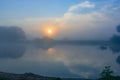 Orange sunrise over the river surface with fog in summer morning. River landscape at sunrise Royalty Free Stock Photo