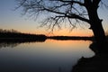 Orange sunset behind the forest over the river in early spring Royalty Free Stock Photo