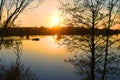 Orange sunset behind the forest over the river in early spring Royalty Free Stock Photo