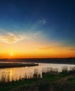 Orange sunset in dark blue sky over river Royalty Free Stock Photo