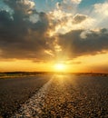 Orange sunset in low dramatic clouds over asphalt road Royalty Free Stock Photo