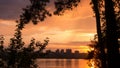 Orange sunset over the city with the buildings silhouettes