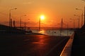 Orange sunset over the highway with a bridge over the river and