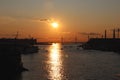 Orange sunset over the river with a bridge and boats