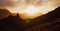 Orange sunset over silhouette of mountains. Picturesque landscape in twilight. Cloudy colourful sky. Tenerife, Canary Royalty Free Stock Photo