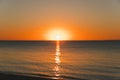 Orange sunset over water near the beach. Royalty Free Stock Photo