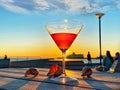 Orange Sunset at pier people relaxing on promenad and glass of juice on wooden table in Tallinn Baltic Sea  travel to Estonia Royalty Free Stock Photo