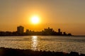 Orange sunset at the sea with buildings in the background in Havana, Cuba