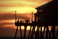 Orange sunset sky with silhouettes of people and the Huntington Beach Pier Royalty Free Stock Photo