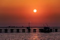 Orange sunset at wooden pier and fishing boat Royalty Free Stock Photo
