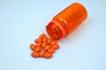 Orange supplements medical pills capsules and tablets spilling out of a drug bottle. Alternative medical, holistic anti aging Royalty Free Stock Photo