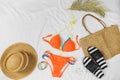 Orange swim suit, straw hat, straw bag, flip flops on white background. Summer concept, clothes for vacation, summer holidays . Royalty Free Stock Photo