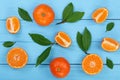 Orange or tangerine with leaves on blue wooden background. Flat lay, top view. Fruit composition