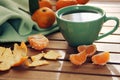 Orange tangerine and mandarin slices, green cup of tea Royalty Free Stock Photo