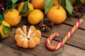 Orange tangerines with leaves on a wooden background, new year