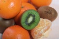 Orange tangerines. One without a peel. Kiwi fruit cut in half. Juicy green flesh is visible. Close-up shot Royalty Free Stock Photo