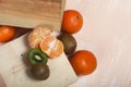 Orange tangerines. One without a peel. Kiwi fruit cut in half. Juicy green flesh is visible. Close-up shot Royalty Free Stock Photo