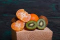 Orange tangerines. One without a peel. Kiwi fruit cut in half. Juicy green flesh is visible. Close-up shot Royalty Free Stock Photo