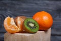 Orange tangerines. One without a peel. Kiwi fruit cut in half. Juicy green flesh is visible. Close-up shot Royalty Free Stock Photo