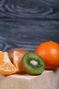 Orange tangerines. One without a peel. Kiwi fruit cut in half. Juicy green flesh is visible. Close-up shot Royalty Free Stock Photo