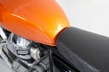 Orange tank and twin motor of a classic motorcycle detail Royalty Free Stock Photo