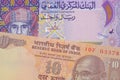 A orange ten rupee bill from India paired with a colorful one rial note note from Oman.