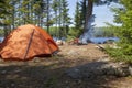 Orange tent and campfire on a lake in the Boundary Waters of northern Minnesota during summer Royalty Free Stock Photo