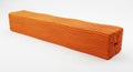 Orange textured rectangular object on a white surface showing its lengthwise corrugated pattern Royalty Free Stock Photo