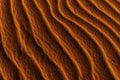 Orange toned sand background with a wavy pattern Royalty Free Stock Photo