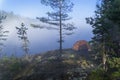 Orange tourist tent against a hazy lake. Karelia, Russia. Royalty Free Stock Photo