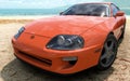 Orange Toyota Supra in beach