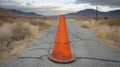 Orange Traffic Cone on a Cracked Desert Road Royalty Free Stock Photo