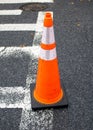 an orange traffic cone is sitting on the street corner next to the white line Royalty Free Stock Photo