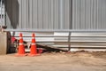 Orange traffic-cones around construction-area in front of corrugated iron for safety. Royalty Free Stock Photo