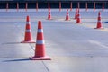 Orange traffic cones with plastic warning poles on entrance way that connect to main road