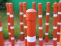 Orange Traffic Pillars in Rows Beside Grass Field