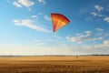 Orange Triangle Kite Flying Over Golden Field Under Blue Sky Royalty Free Stock Photo