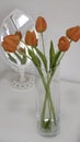 Orange tulips in a glass vase and a little table mirror in the background Royalty Free Stock Photo