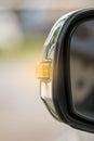 Orange turn signal indicator on the left side mirror of the car To signal other cars Before the car turns to the left While Royalty Free Stock Photo