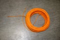 Orange twisted pair cable isolated on floor of data center