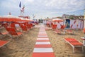 Orange umbrellas and chaise lounges on the beach of Rimini in It