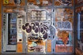 orange vending machines completely vandalized and full of graffiti and radical stickers