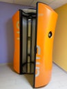 Orange vertical tanning booth.