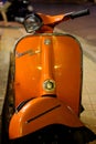 An Orange Vespa Motorcycle, retro style.